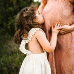 child kissing woman's tummy