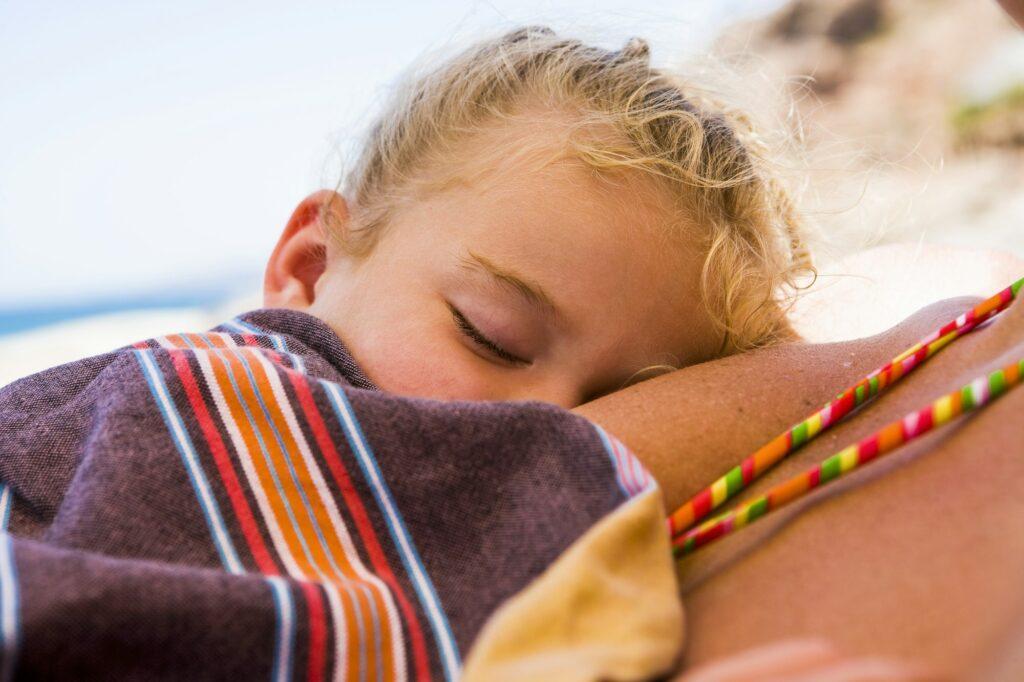 sleeping 3 year old girl on beach