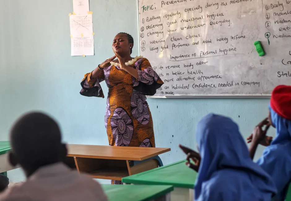 A classroom lesson on personal hygiene led by a female teacher engaging students.