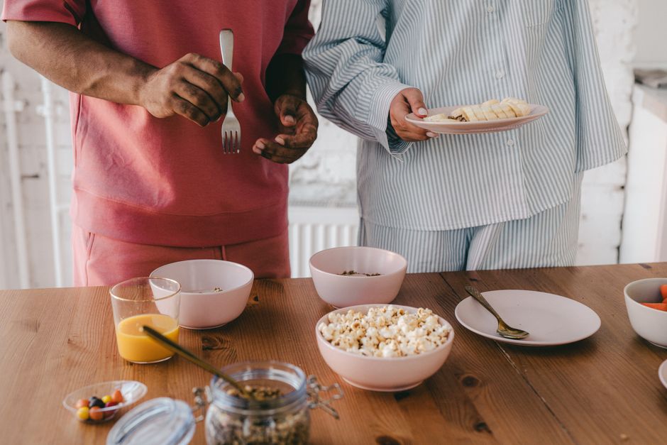 Après 70 ans, le couple change de rythme : 5 repères pour rester proches A couple in pajamas sharing a healthy breakfast at home, emphasizing togetherness.
