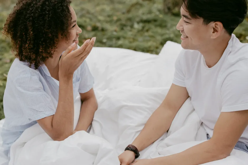 Amour romantique : 7 mythes qui prennent un râteau A happy couple smiling and chatting outdoors in a relaxed, romantic setting.