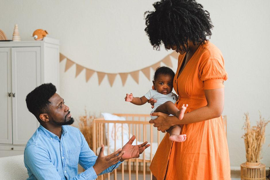 Couple après bébé : 5 priorités quand tout déborde, même la vaisselle A loving family moment with parents and baby at home, embracing warmth and togetherness.