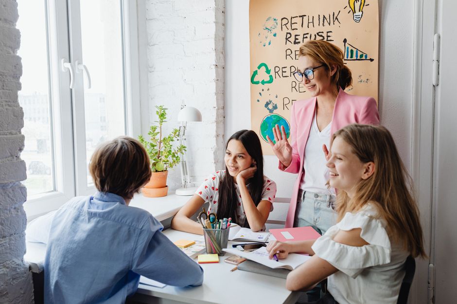 Mariage précoce avant 18 ans : 4 leviers de terrain, sans recette magique A teacher engages with students in a bright classroom setting, fostering creativity and discussion.