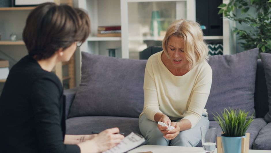 Amour et santé : 4 décisions intimes où le cœur ne suffit pas A woman in therapy session with a professional therapist, expressing emotions.