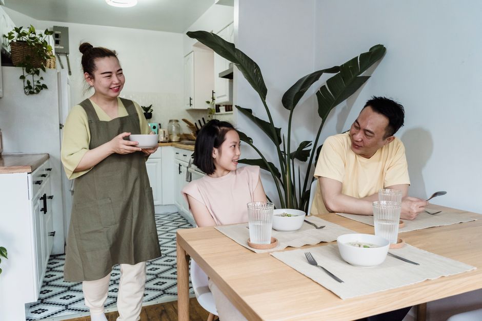 Family mealtime with parents and daughter sharing a meal at home, fostering togetherness.