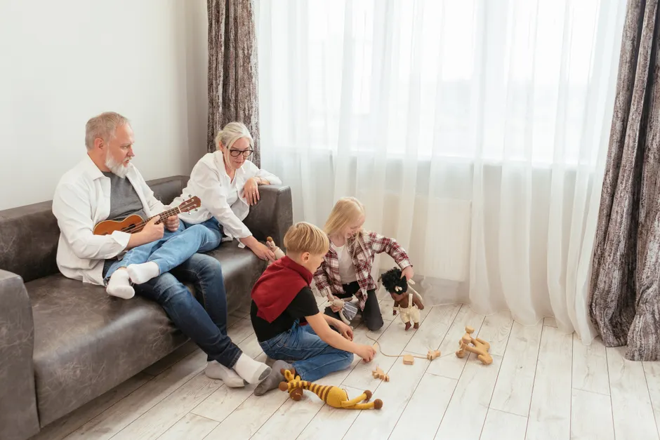 Enfants et couple : 3 187 adultes dans 25 pays, le nombre n’est pas le coupable Grandparents enjoy music while children play with toys in a cozy living room.