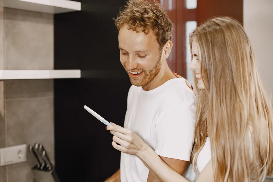 Stress parental et couple : 29 études, 752 femmes et 52 semaines, la vaisselle en embuscade Joyful couple celebrating a positive pregnancy test result at home.