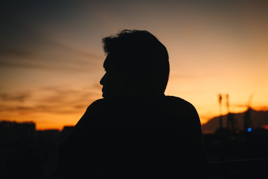 Amour romantique : 6 mythes qui prennent un râteau Silhouette of a person against a vibrant sunset sky, creating a dramatic scene.