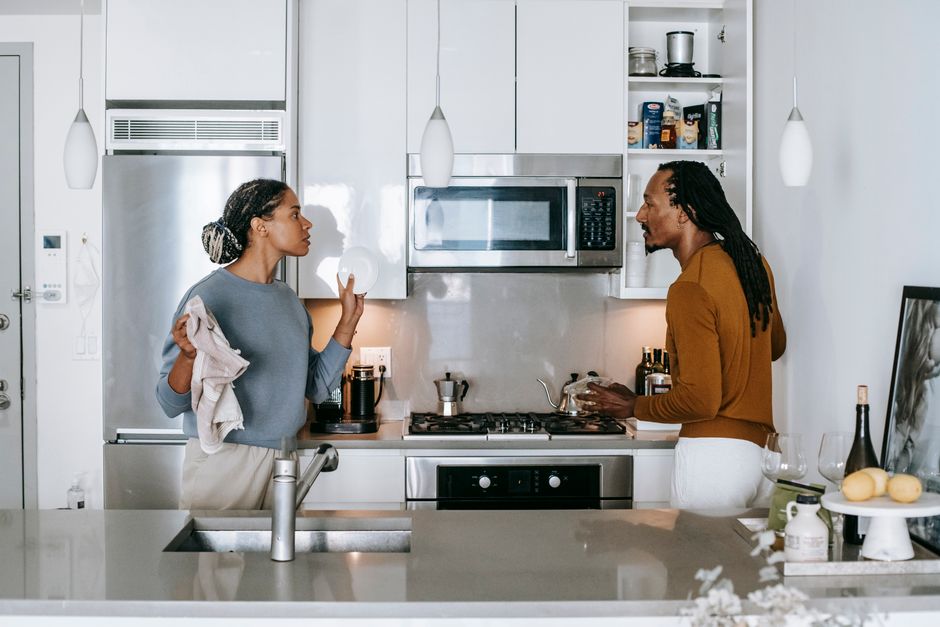 Grandir ensemble en couple : 5 pistes quand la maison déborde Young black woman talking to annoyed male partner while looking at each other during quarrel in house