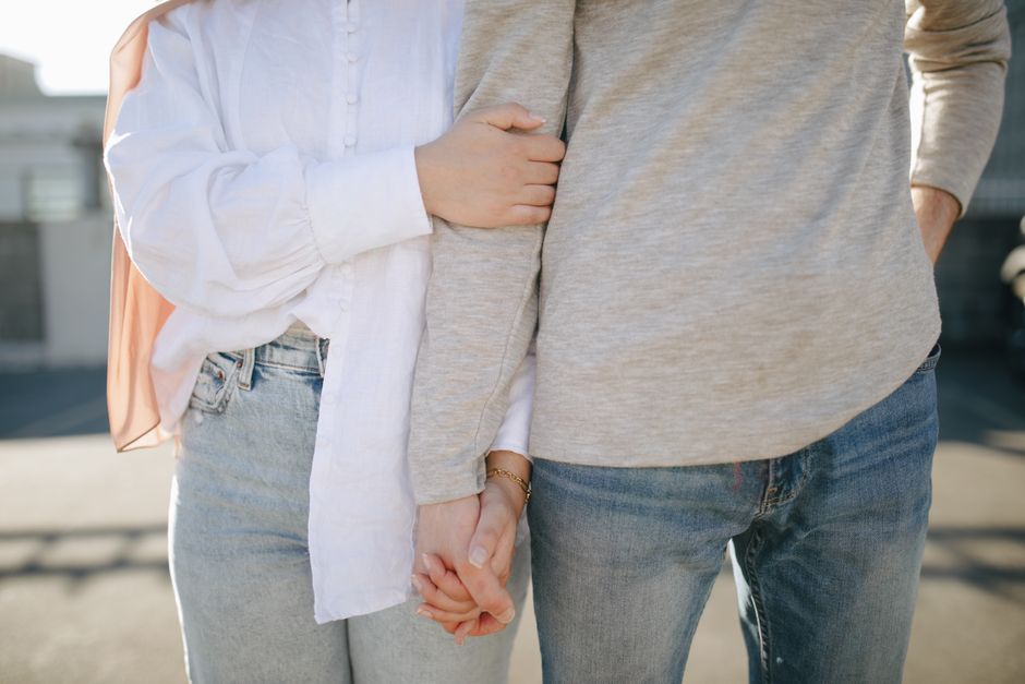 Amour Eros : 3 repères pour vivre la passion sans se perdre A close-up view of a couple holding hands and wearing casual attire outdoors.