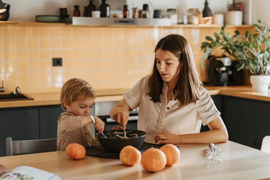 À 6 ans, santé mentale de l’enfant : le revenu n’explique pas tout A mother and child bond over baking in a warm kitchen setting with pumpkins.