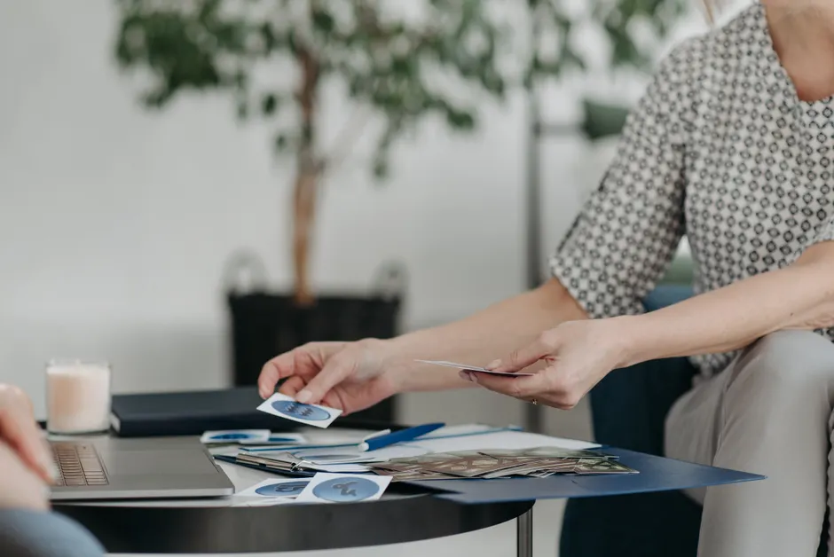 A woman organizes and sorts cards on a coffee table in a comfortable living room setting.