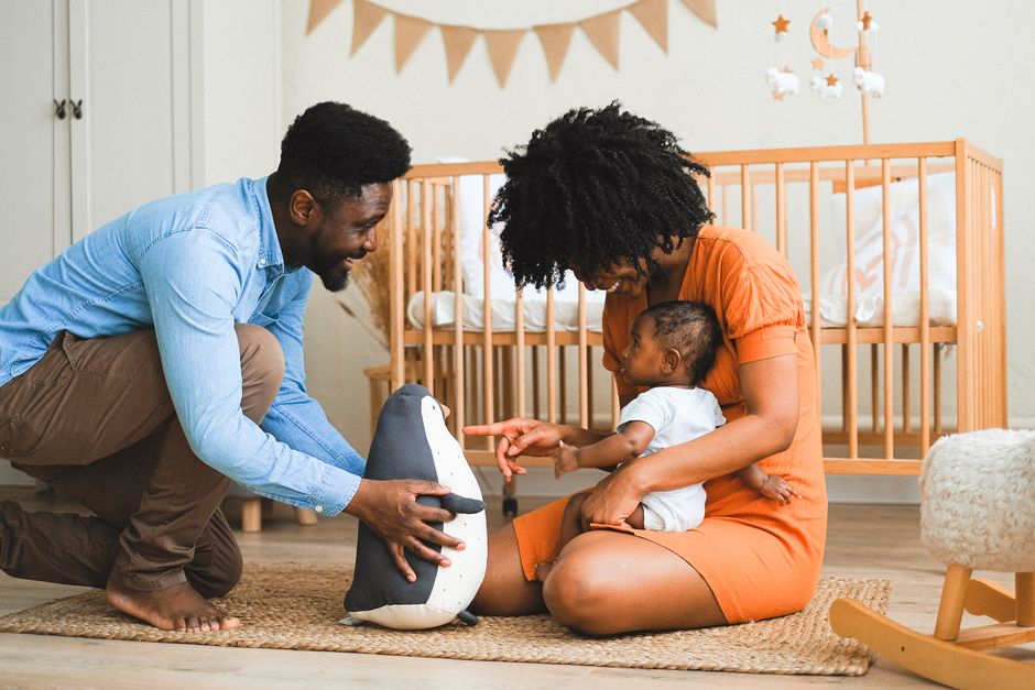 De 0 à 3 ans, l’attachement parent-enfant ouvre des chemins, pas un destin Cheerful parents bonding with baby in modern nursery, experiencing precious moments.