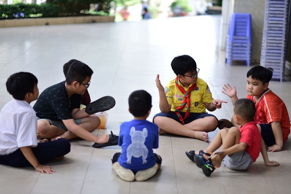 Amitiés de 6 à 16 ans : 4 études, sans recette miracle Children gathered in a discussion indoors, engaging and interacting together.