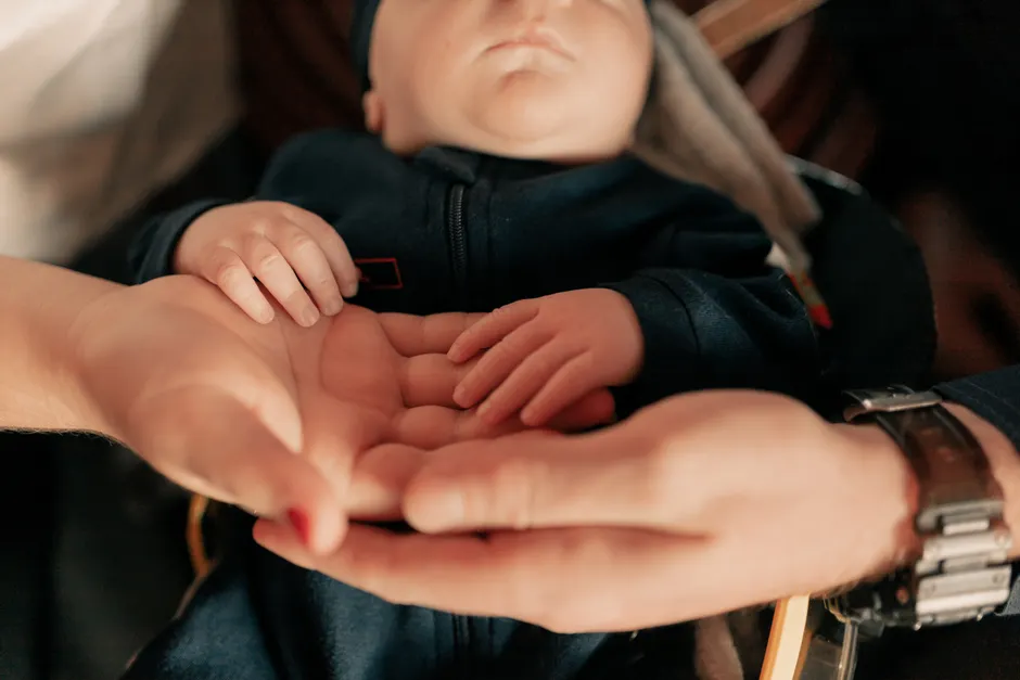 Aimer sans posséder : 3 repères pour le couple Close-up of parents holding their baby's hands, symbolizing love and protection.