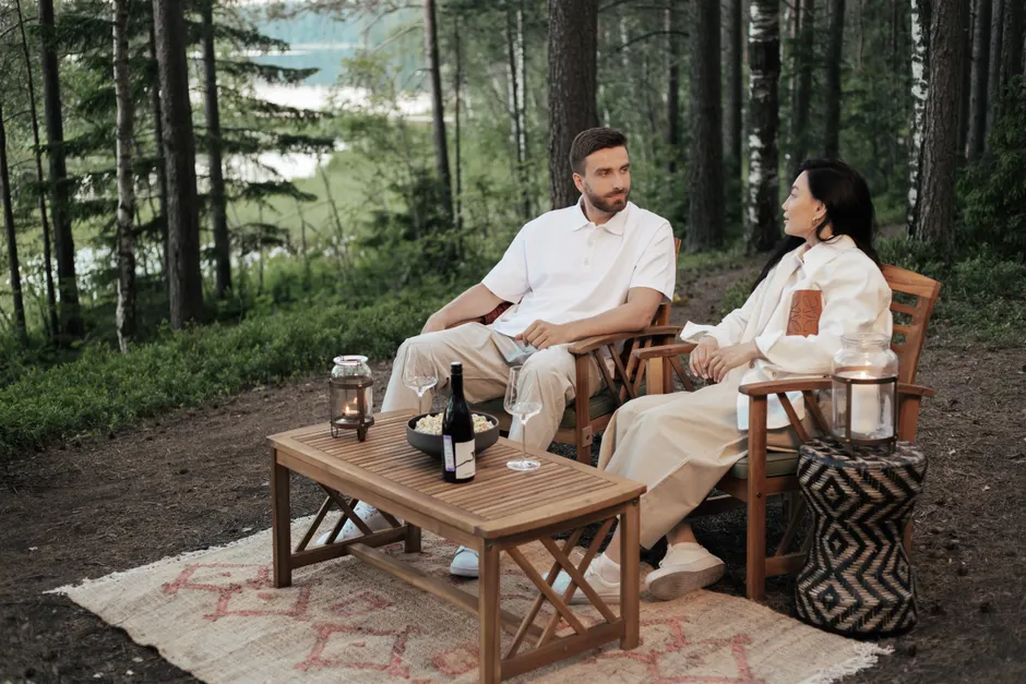 Manifester une relation saine : 5 choix concrets, sans magie Couple enjoying a serene picnic with wine and conversation in a lush forest.