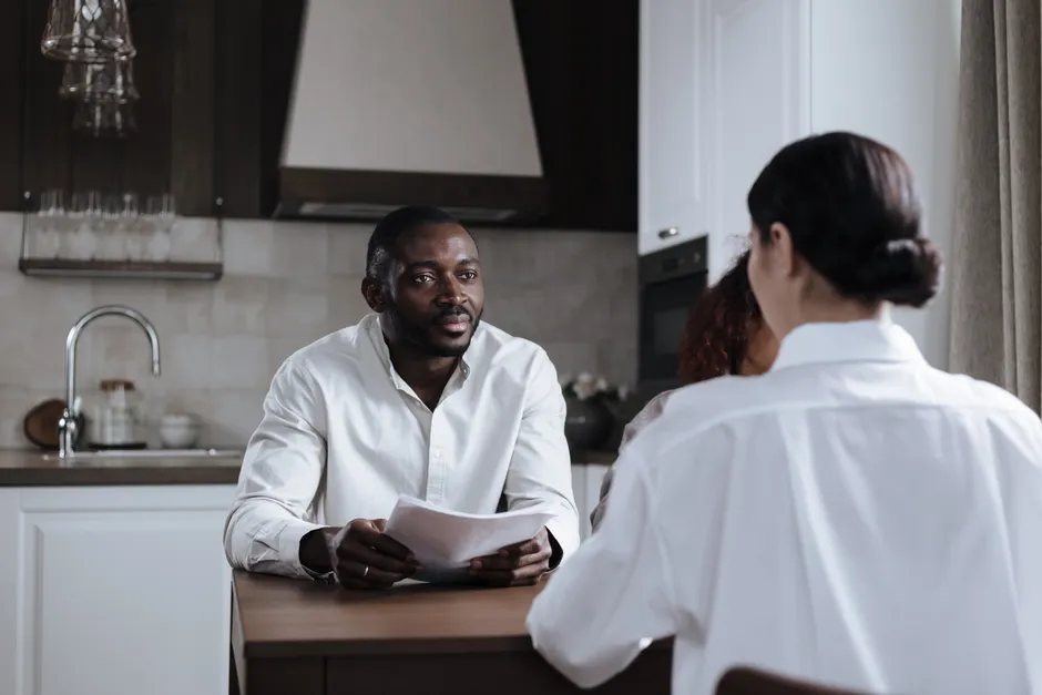 Couple : 7 habitudes à tester quand le quotidien déborde Couple having a thoughtful conversation at home in a modern kitchen setting.
