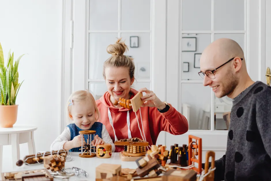 Family enjoying quality time playing with wooden toys in a cozy home setting, fostering creativity and bonding