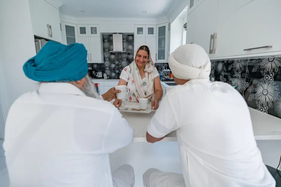 Amour et respect en famille : 5 repères pour le quotidien, sans mode d’emploi Family members engaging in conversation at a modern kitchen counter indoors.