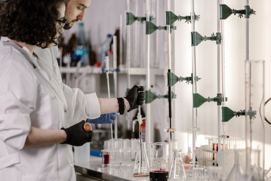 Graphène oxyde en 2026 : deux pistes, cinq limites Scientists in lab coats work with test tubes in a modern laboratory.
