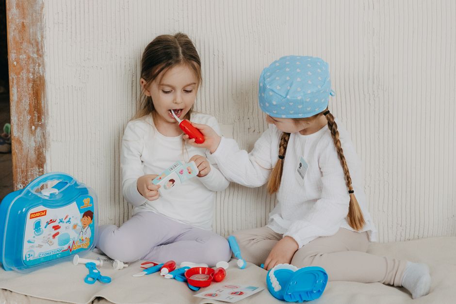Filles et garçons : 503 188 réponses sur les intérêts, pas sur les jouets Two children playing dentist at home with a toy set, learning and having fun.