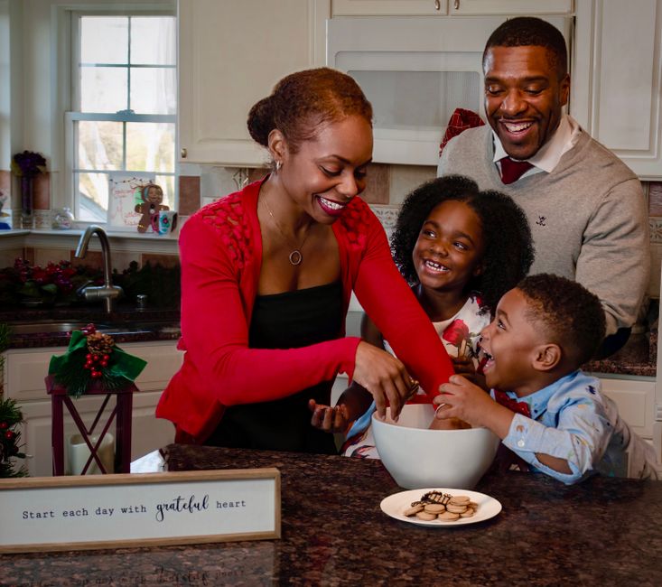 Gratitude dans le couple : 7 gestes en 7 jours, sans grand soir A joyful family baking cookies together in a cozy kitchen setting.
