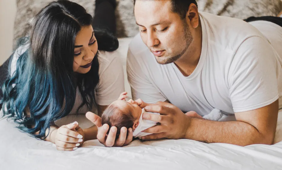 Après bébé, 5 limites relationnelles à poser sans s’épuiser A loving family shares a tender moment with their newborn baby at home.