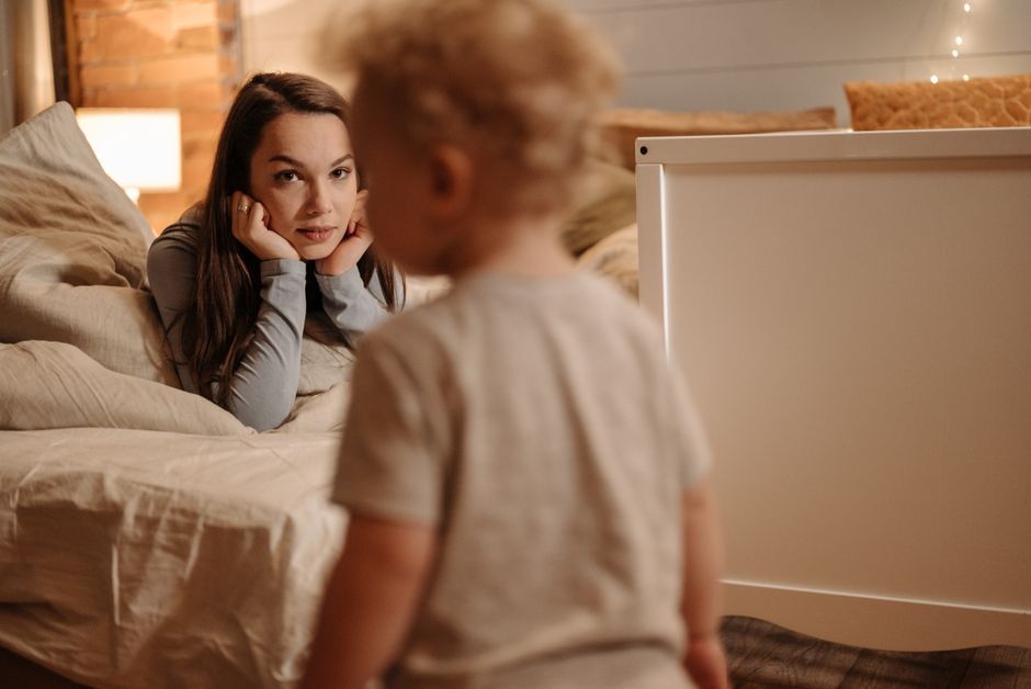 À 29 mois, parler ne se commande pas : 4 réflexes pour échanger A tender moment captured between a mother and her toddler in a warmly lit bedroom.